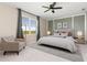 Stylish bedroom with a neutral color palette, large window with curtains, and a comfortable-looking armchair at 17605 Boracay Ct # 201, Venice, FL 34293