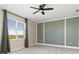 Bright bedroom with large window with green accent wall and a modern ceiling fan at 17605 Boracay Ct # 201, Venice, FL 34293