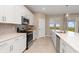 Bright kitchen featuring white cabinets, stainless steel appliances, and a large island with a sink and counterspace at 17605 Boracay Ct # 201, Venice, FL 34293
