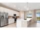 Modern kitchen with stainless steel appliances, white cabinets, and a large island perfect for meal preparation and dining at 17605 Boracay Ct # 201, Venice, FL 34293