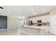 Spacious open kitchen boasts white cabinets, stainless appliances, island with pendant lights, and lots of counter space at 17605 Boracay Ct # 201, Venice, FL 34293