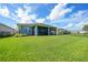 Spacious backyard offers great outdoor living with manicured lawn and a screened-in patio at 17921 Grand Prosperity Dr, Venice, FL 34293