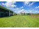Expansive backyard with lush green grass, and a black metal fence at 17921 Grand Prosperity Dr, Venice, FL 34293