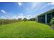 A spacious backyard with lush green grass and a black metal fence at 17921 Grand Prosperity Dr, Venice, FL 34293