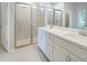 Bright bathroom with double vanity, white cabinets, quartz countertop, and large glass enclosed shower at 17921 Grand Prosperity Dr, Venice, FL 34293