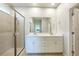 Bright bathroom with double vanity, white cabinets, quartz countertop, and large glass enclosed shower at 17921 Grand Prosperity Dr, Venice, FL 34293