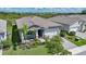 Charming home with a well-manicured lawn, lush landscaping, and a tile roof at 17921 Grand Prosperity Dr, Venice, FL 34293