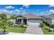Beautiful single-story home with well manicured lawn, stone accents, and a brick paver driveway at 17921 Grand Prosperity Dr, Venice, FL 34293