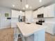 Bright kitchen with white cabinets, a large island, and stainless steel appliances at 17921 Grand Prosperity Dr, Venice, FL 34293