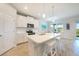 Bright kitchen features an island with sink, white cabinets, and stainless steel appliances at 17921 Grand Prosperity Dr, Venice, FL 34293