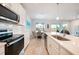 Bright kitchen with white cabinets, stainless steel appliances, and a view into the adjacent dining area at 17921 Grand Prosperity Dr, Venice, FL 34293
