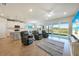 Open living room with leather recliners, a large-screen TV, and sliding glass doors to the lanai at 17921 Grand Prosperity Dr, Venice, FL 34293