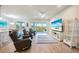 Spacious living room with recliners, TV, and sliding doors to the lanai providing ample natural light at 17921 Grand Prosperity Dr, Venice, FL 34293