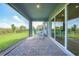 Covered patio featuring brick floor and comfortable seating, with a view of the lawn at 17921 Grand Prosperity Dr, Venice, FL 34293