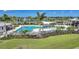Aerial view of a beautiful pool area with cabanas, lounge chairs, and well-maintained landscaping at 17921 Grand Prosperity Dr, Venice, FL 34293
