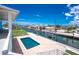 An exterior view of a private swimming pool, boat lift, and canal at 1930 Massachusetts Ave, Englewood, FL 34224