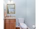 Powder room features a pedestal sink with a golden framed mirror and blue wall at 1930 Massachusetts Ave, Englewood, FL 34224