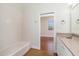 Bathroom with bathtub and view into an adjacent bedroom with concrete floors at 1930 Massachusetts Ave, Englewood, FL 34224