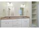 Bright bathroom with double sink vanity, modern fixtures, and a set of shelves at 1930 Massachusetts Ave, Englewood, FL 34224