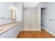 Neutral bathroom featuring a vanity, framed mirror, and frameless glass shower with shelves at 1930 Massachusetts Ave, Englewood, FL 34224