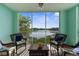 Enclosed balcony featuring wicker furniture and overlooking a scenic lake at 19375 Water Oak Dr # 203, Port Charlotte, FL 33948