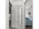 Bright hallway with tiled floor leads to a bathroom, laundry area, and bedroom at 19375 Water Oak Dr # 203, Port Charlotte, FL 33948