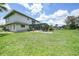 Spacious backyard with lush greenery, screened-in pool, and patio area at 196 Lecturn St, Port Charlotte, FL 33954