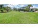 Expansive backyard featuring lush greenery, palm trees, and screened-in pool at 196 Lecturn St, Port Charlotte, FL 33954