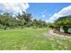 Expansive backyard with lush greenery, palm trees, and garden beds at 196 Lecturn St, Port Charlotte, FL 33954