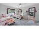 Cozy bedroom featuring two beds with floral comforters, soft gray carpet, and decorative window treatments at 196 Lecturn St, Port Charlotte, FL 33954