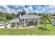 Two-story home with a large yard, lush landscaping, and screened-in front porch at 196 Lecturn St, Port Charlotte, FL 33954