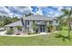 Daytime view of a stately two-story home with lush landscaping, a portico entrance, and mature palm trees at 196 Lecturn St, Port Charlotte, FL 33954