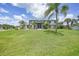 Two-story home with a large yard, lush landscaping, and screened-in front porch at 196 Lecturn St, Port Charlotte, FL 33954