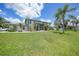 Two-story home with a large yard, lush landscaping, and screened-in front porch at 196 Lecturn St, Port Charlotte, FL 33954