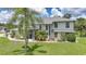 Two-story home with a well-manicured lawn, lush landscaping, and screened-in front porch at 196 Lecturn St, Port Charlotte, FL 33954