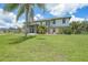 Two-story home with a large yard, lush landscaping, and screened-in front porch at 196 Lecturn St, Port Charlotte, FL 33954