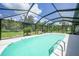 Well-maintained screened pool features an inviting design and ladder entrance, surrounded by lush landscaping at 196 Lecturn St, Port Charlotte, FL 33954