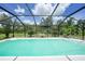 Inviting screened pool area with refreshing water, a small bench, and serene views of the surrounding greenery at 196 Lecturn St, Port Charlotte, FL 33954