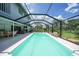 This view highlights the screened-in pool with views of the manicured lawn and tropical foliage at 196 Lecturn St, Port Charlotte, FL 33954