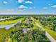 Aerial view showcases a house with a pool next to a golf course and waterway at 23 Pine Valley Ct, Rotonda West, FL 33947