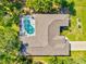 Aerial view of a home with a screened-in pool, showcasing the layout and roof design at 23 Pine Valley Ct, Rotonda West, FL 33947