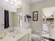 Clean bathroom with a sink, toilet, and door that leads to an outdoor seating area at 23 Pine Valley Ct, Rotonda West, FL 33947