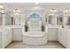 Bright bathroom featuring a soaking tub, dual vanities, and a large window for natural light at 23 Pine Valley Ct, Rotonda West, FL 33947