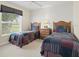 Bedroom featuring two twin beds, a nightstand, and a window with natural light at 23 Pine Valley Ct, Rotonda West, FL 33947