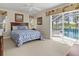 Comfortable bedroom with a queen-sized bed, sliding glass door to the pool, and bright natural light at 23 Pine Valley Ct, Rotonda West, FL 33947