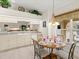 Breakfast nook with a cozy round table and a view of the kitchen with a window overlooking the backyard at 23 Pine Valley Ct, Rotonda West, FL 33947