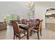 Open dining area with wood floors, table set for six, and views into the living room and kitchen at 23 Pine Valley Ct, Rotonda West, FL 33947
