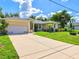 Welcoming home featuring an attached two-car garage and expansive driveway in a desirable neighborhood at 23 Pine Valley Ct, Rotonda West, FL 33947