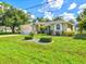 Charming single-story home boasting a well-manicured lawn and lush landscaping under a bright blue sky at 23 Pine Valley Ct, Rotonda West, FL 33947