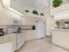 Well-lit kitchen featuring all-white appliances, cabinets, and vaulted ceilings with unique plant shelf at 23 Pine Valley Ct, Rotonda West, FL 33947